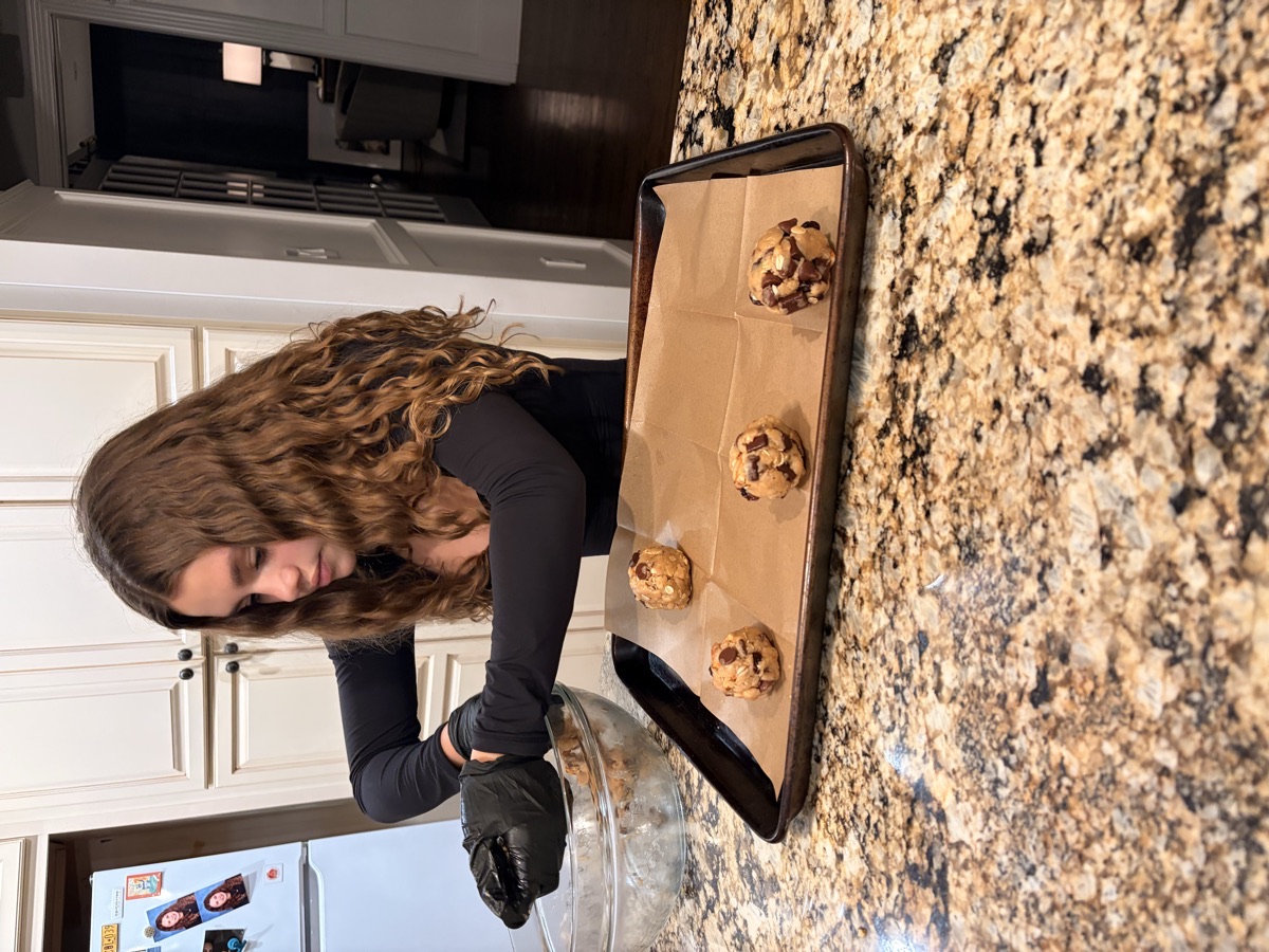 A girl placing balls of Everything dough onto a lined tray