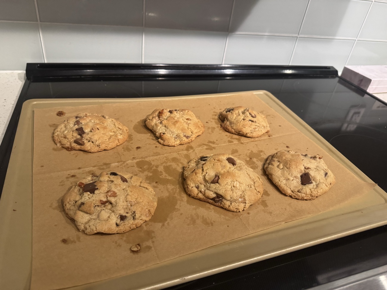 Six baked Everything cookies on a lined tray on the stovetop