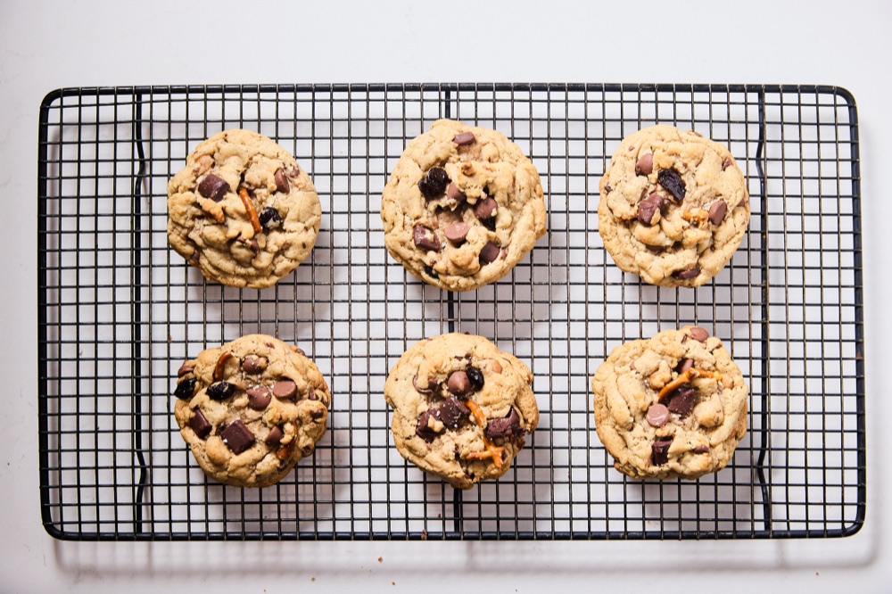 Six baked Everything cookies cooling on a rack
