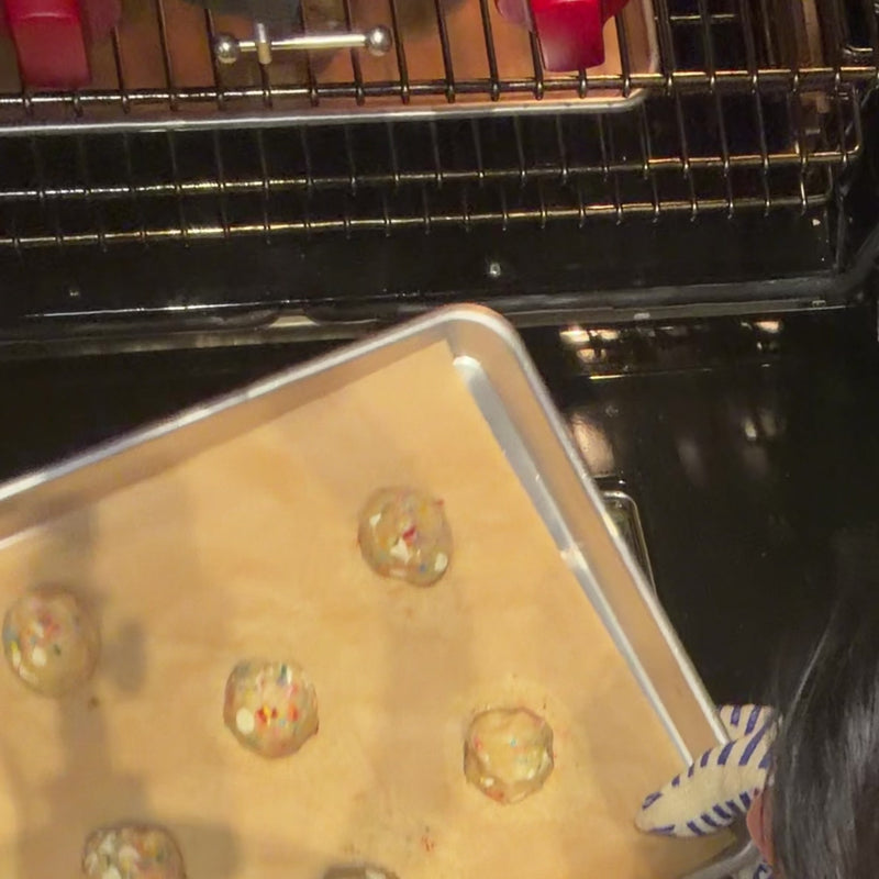 Freshly baked The Everything cookies with golden edges on a parchment-lined sheet